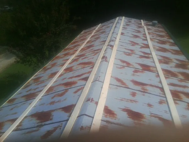 Rusted metal roof panels with new wood purlins before replacement — Storm Damage Roof Repair in Sandusky by Roofing Brothers