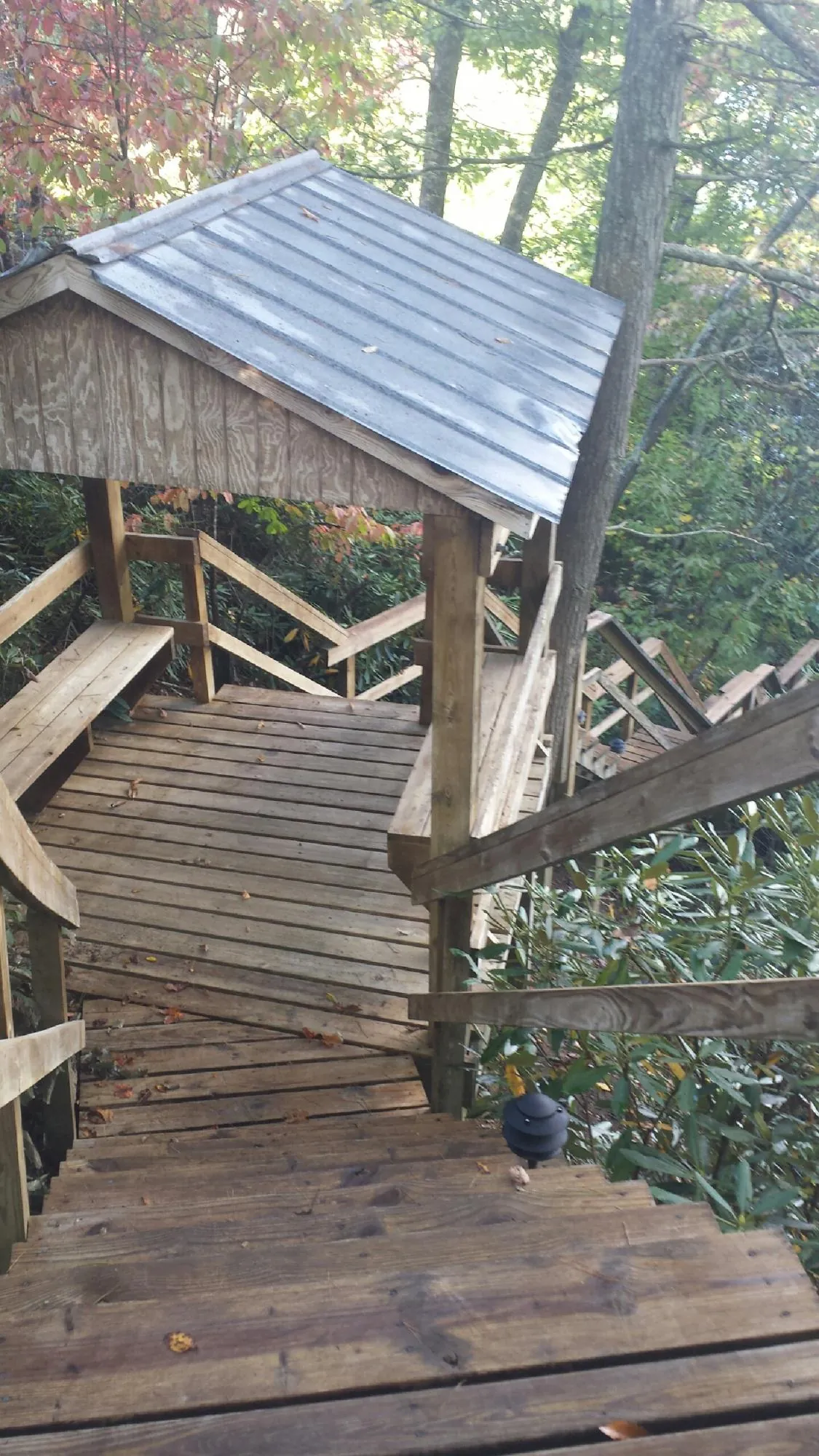 Metal roofed shelter over wooden steps on a wooded walkway — Skylight Repair & Installation work by our crew in Sandusky